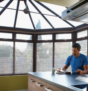 man sitting in conservatory looking at papers