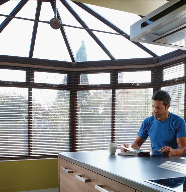man sitting in conservatory looking at papers